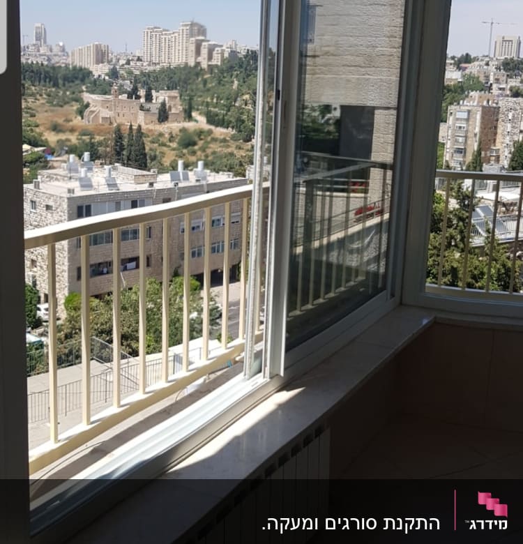 חלון זכוכית עם מסגרת לבנה ונוף עירוני